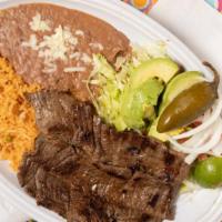 Carne Asada · Steak served with rice, beans, lettuce, onions and tortillas.