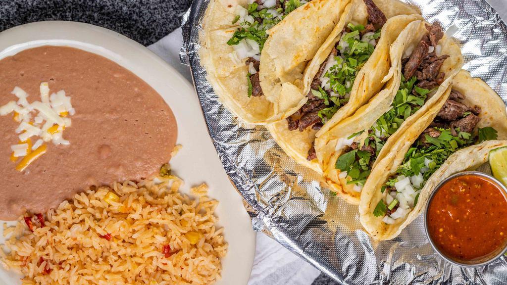 Street Tacos · Four tacos on corn tortilla with your choice of steak, chicken, chorizo, carnitas, or pastor topped with onion & cilantro. Served along with rice and beans & sauce. Mix & match for an additional charge.