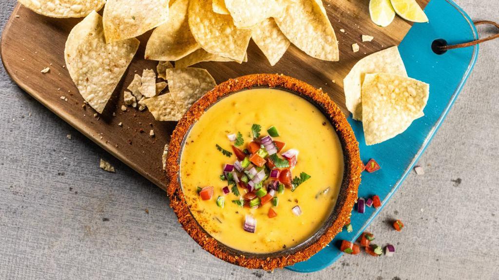 Chips & Queso · Three-cheese queso topped with fresh pico de gallo and served with crispy tortilla chips.