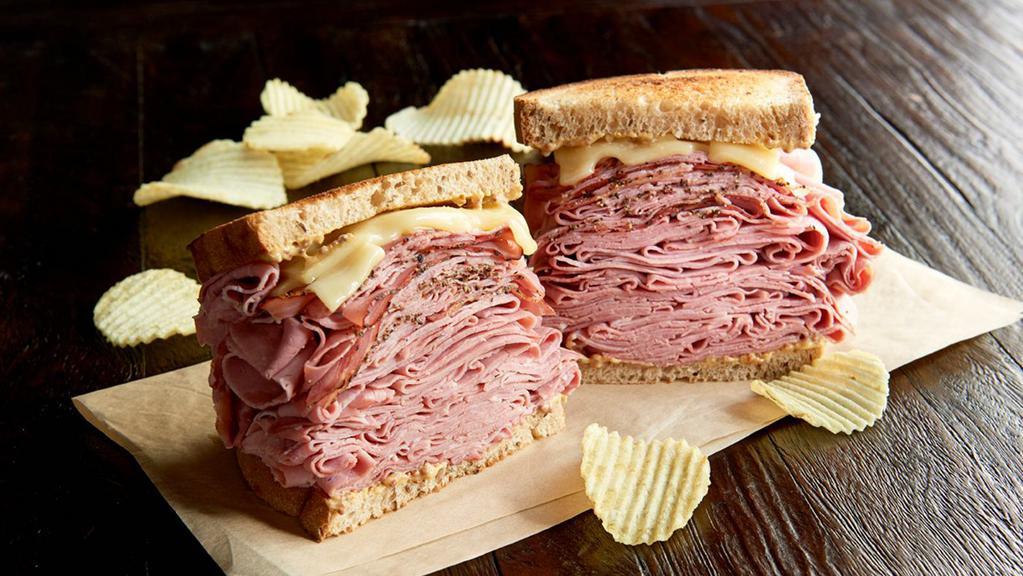 The New York Yankee Regular · 3/4 pound combo of hot corned beef and pastrami, Swiss on toasted marbled rye. Served with chips or baked chips (150/100 cal) and a pickle (5 cal).
