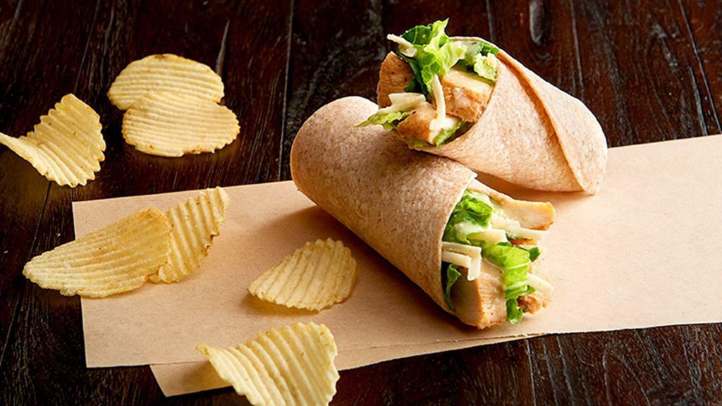 Chicken Caesar Salad Wrap Regular · Grilled, 100% antibiotic-free chicken breast, romaine, Asiago, Caesar dressing, on a toasted organic wheat wrap. Served with chips or baked chips (150/100 cal) and a pickle (5 cal).