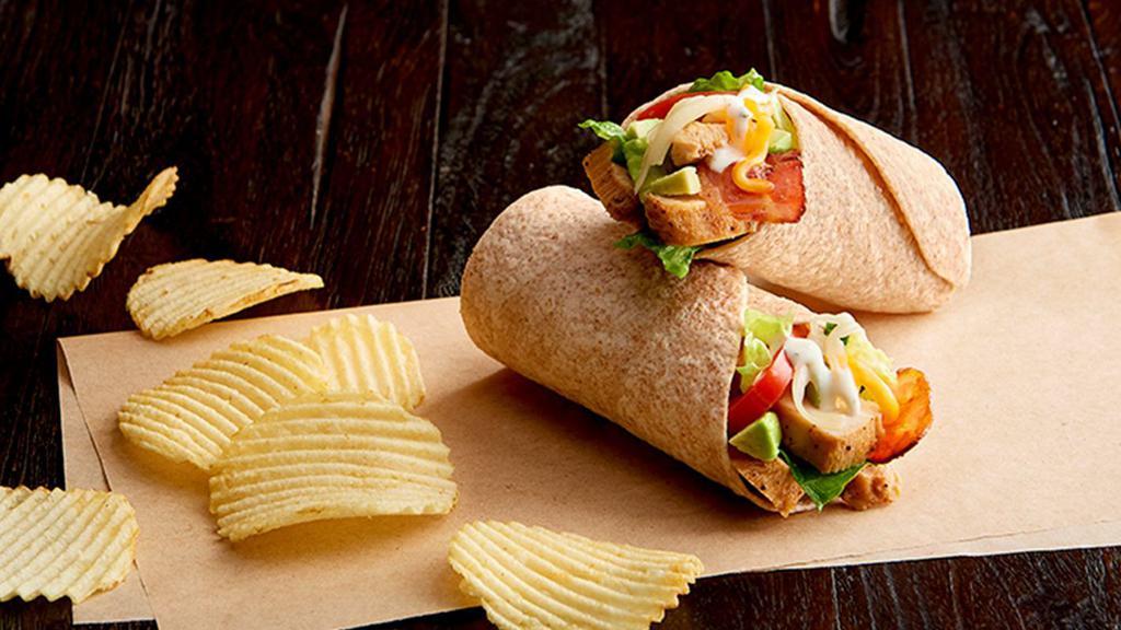 Chicken Club Salad Wrap Regular   · Grilled, 100% antibiotic-free chicken breast, grape tomatoes, sliced avocado, cheddar, Asiago, bacon, mixed salad greens, ranch dressing, in a toasted organic wheat wrap. Served with chips or baked chips (150/100 cal) and a pickle (5 cal).