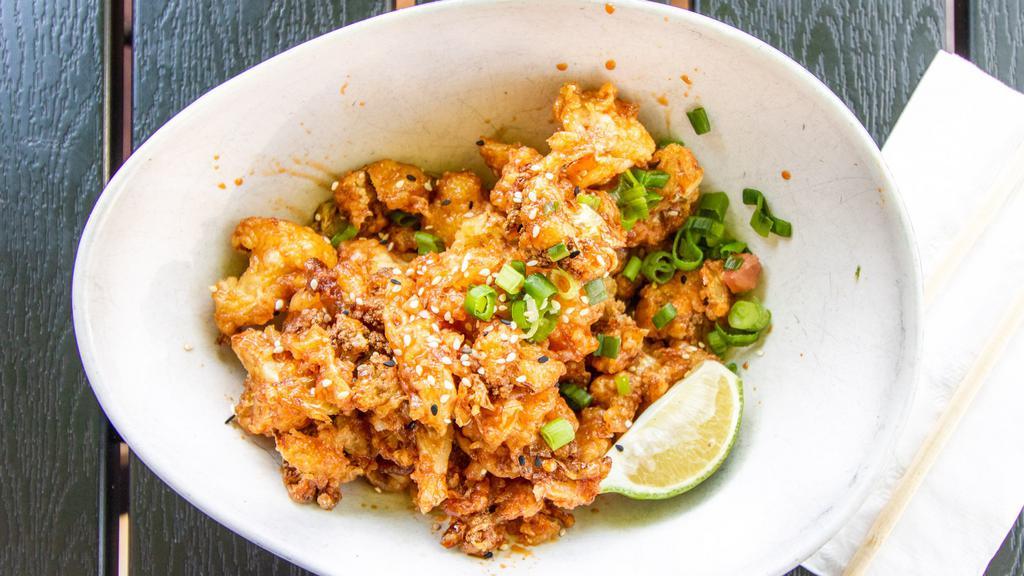 Korean Fried Cauliflower · Crispy cauliflower tossed with a Korean sweet and spicy sauce and topped with green onions and sesame seeds.