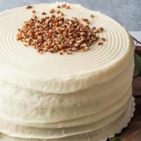 White Chocolate No Nuts Layer Cake · White chocolate cake with cream cheese frosting and pecans sprinkled on top.