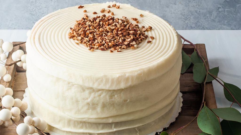 White Chocolate No Nuts Layer Cake · White chocolate cake with cream cheese frosting and pecans sprinkled on top.