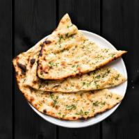 Garlic Naan · House-made pulled and leavened dough pressed with garlic and baked to perfection in an India...