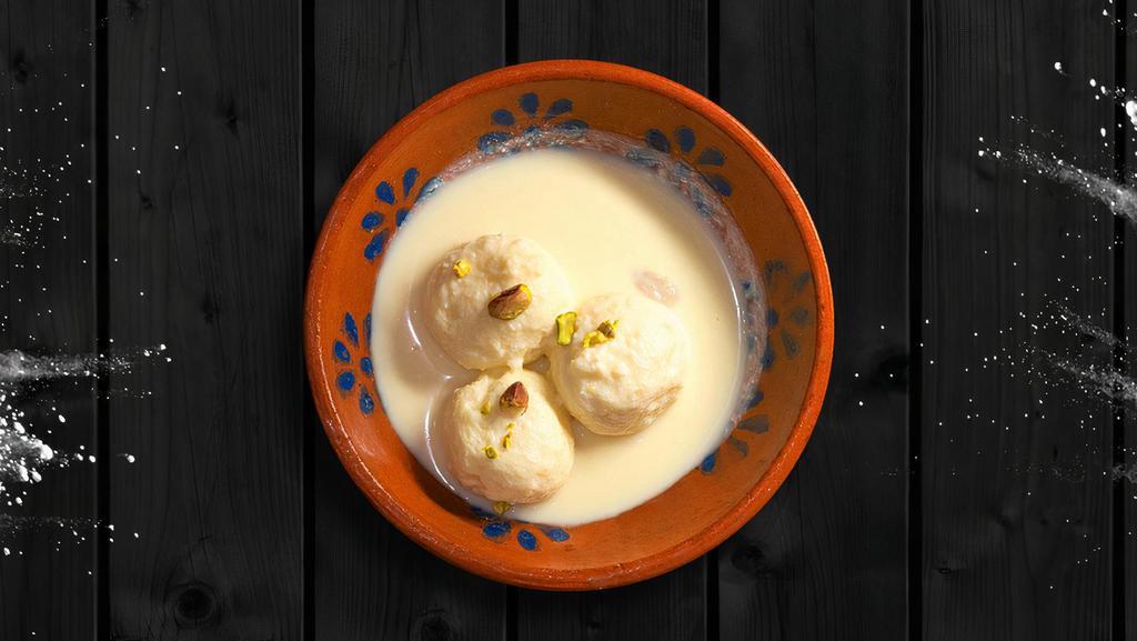 Rasmalai · Two pieces. Soft, small, and spongy flattened balls made by milk dunked in flavored sweet milk and pistachio.