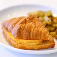 Egg & Cheeze Croissandwich · Vegan croissant, just egg patty, cheddar “cheese”, served with a side of golden fries