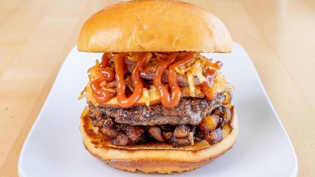 Pipo'S Choice · Our signature 100% fresh beef patty on a bed of fried plantain bits, topped with smoked gouda cheese, applewood smoke bacon, grilled onions, papitas, and guava ketchup served between a buttery toasted brioche bun.     .     .     .