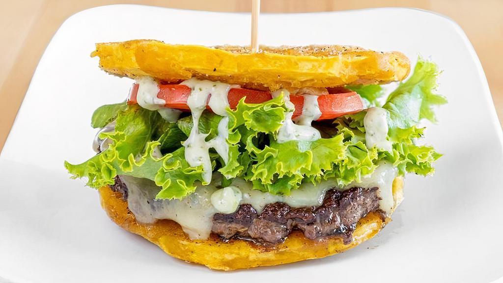 Toston Burger · Our signature 100% fresh beef patty topped with jack cheese, lettuce, tomatoes, and cilantro sauce between two fried plantains as buns.