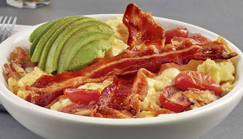 Avocado Bacon Scramble Bowl · Avocado, bacon, scrambled eggs, and roasted grape tomatoes served over hashbrown potatoes and drizzled with hollandaise sauce.