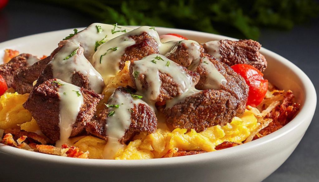 Steak & Scramble Bowl · Enjoy seasoned sirloin steak, scrambled eggs and roasted grape tomatoes served over hashbrown potatoes and drizzled with hollandaise sauce.