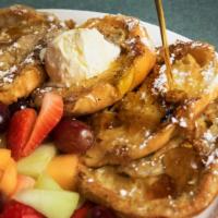 Croissant French Toast · Four pieces of a light, buttery croissant, battered and grilled to perfection. Topped with p...