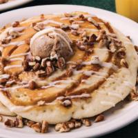 Cinnamon Roll Pancakes · Two fluffy pancakes swirled with cinnamon and sugar, topped with cream cheese icing, candied...