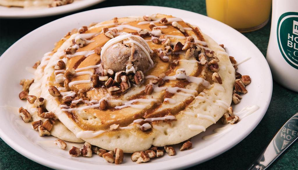 Cinnamon Roll Pancakes · Two fluffy pancakes swirled with cinnamon and sugar, topped with cream cheese icing, candied pecans, and cinnamon butter.