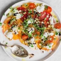 Heirloom Tomato Carpaccio · Thinly slice heirloom tomatoes and spread over a large serving dish topped with burrata, aru...