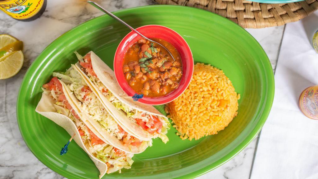 South Of The Border Tacos · Three tacos with your choice of chicken, ground beef, brisket or pulled pork with lettuce, tomatoes and shredded cheese with either a crunchy or soft shell. Served with your choice of rice and beans.