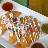 Chicken Empanadas · Homemade corn pastries stuffed with cheese, shredded chicken, and poblano peppers. Topped wi...