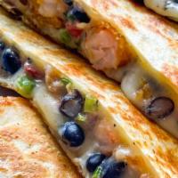Street Corn Shrimp Quesadilla · A flour tortilla stuffed with street corn crusted shrimp, cheese, chipotle crema, and black ...