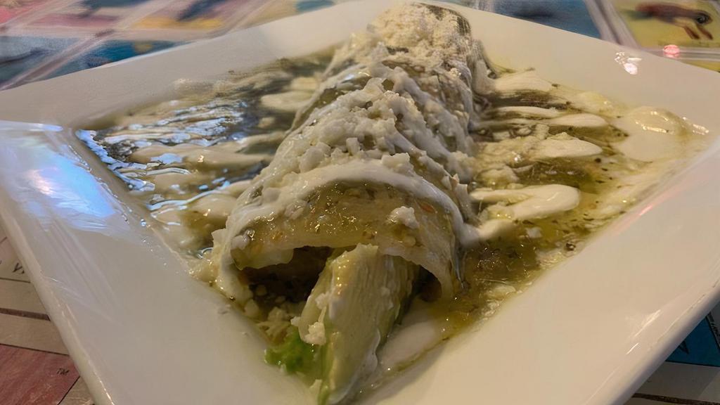 Avocado & Cheese Enchilada · Corn tortilla stuffed with avocado and shredded cheese. Topped with green tomatillo sauce, sour cream, and queso fresco.
