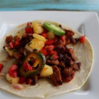 Pineapple Al Pastor Taco · Al pastor (marinated pork), pineapple salsa, and bread and butter jalapeños and onions. Serv...
