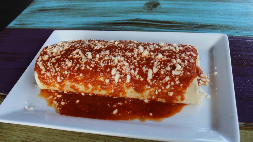 Burrito Supreme · Ground beef or shredded chicken, rice, refried beans, sour cream, queso dip, tomatoes, and lettuce. Topped with red sauce and queso fresco.