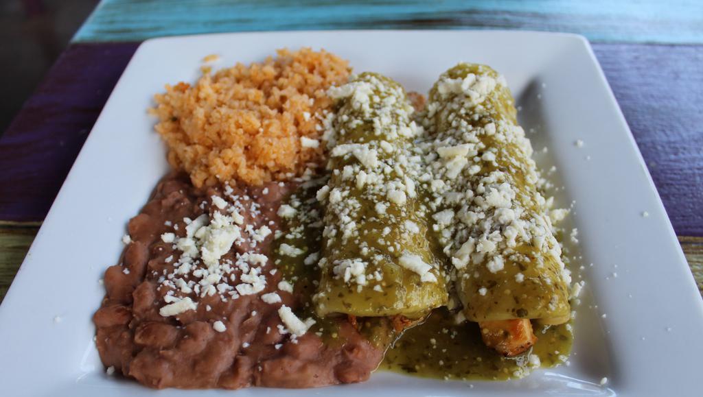 Enchiladas Suizas · Corn tortillas stuffed with grilled chicken and topped with green tomatillo sauce and queso fresco. Served with a side of rice and refried beans.