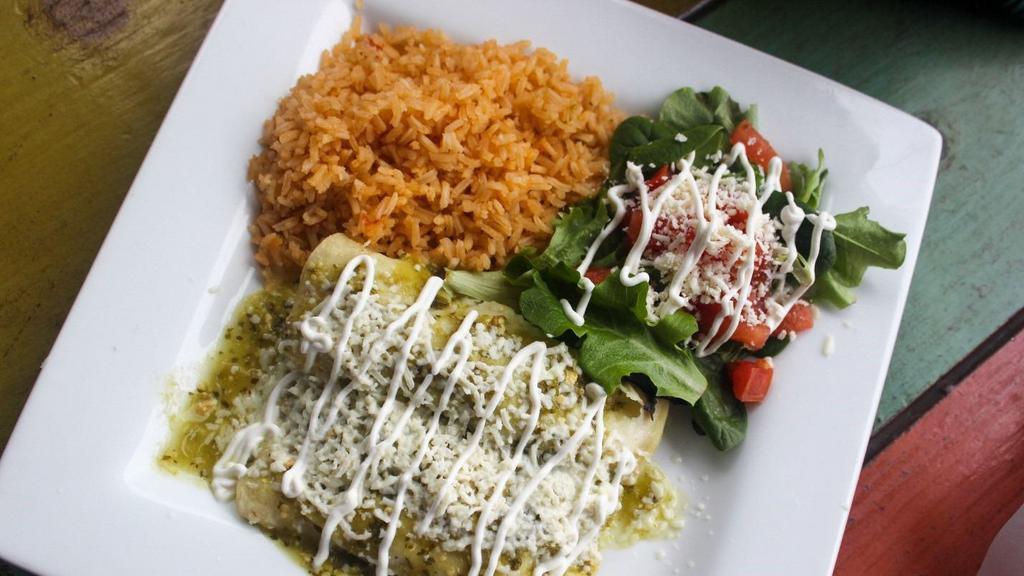 Avocado Enchiladas · Corn tortillas stuffed with avocado and shredded cheese. Topped with green tomatillo salsa, sour cream, and queso fresco. Served with a side of black beans and a side salad (lettuce, sour cream, tomatoes, queso fresco).