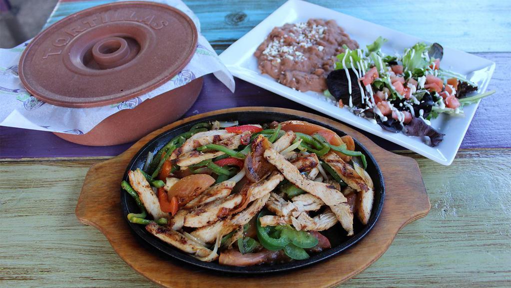 Chicken Fajitas · All fajitas come with grilled onions, bell peppers, and tomatoes. Served with a side of rice, refried beans, side salad (lettuce, sour cream, tomatoes, queso fresco), and flour tortillas.
