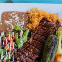 Carne Asada · Marinated charbroiled skirt steak. Served with a side of rice, refried beans, side salad (le...