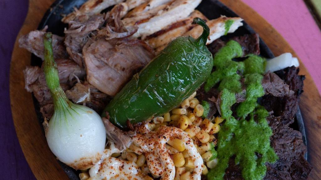 La Parrilla · Marinated charbroiled skirt steak with chimichurri sauce, grilled chicken breast, carnitas, grilled jalapeño, and a spring onion. Served with a side of authentic esquite (Mexican Street Corn salad) and flour tortillas.
