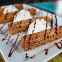 Churros · A cream-filled fried pastry sprinkled with cinnamon and sugar. Topped with a drizzle of choc...