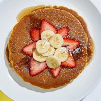 Vegan Berry Pancakes · Two buckwheat pancakes with bananas, blueberries, strawberries, maple syrup and powdered sug...