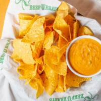 Queso & Chips · A creamy white cheddar cheese sauce blended with ground green chilies, diced onions, garlic ...