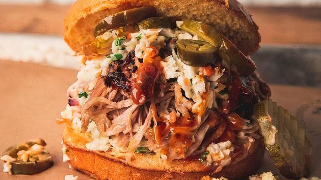 Messy Pig · Heaping pile of pulled pork between 2 layers of Southern Coleslaw, topped with pickles and jalapenos, served on a brioche bun and smothered in 4R Signature Sauce.
