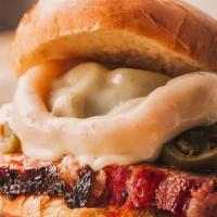 Texas Destroyer · Signature Angus Brisket topped with onion rings, jalapeños, melted provelone cheese, served ...