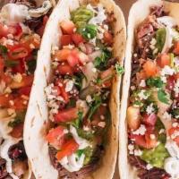 Street Tacos · Signature Angus Brisket topped with cilantro lime crème fraiche, guasacaca, pico de gallo, q...