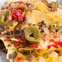 Sirloin Steak Nachos · USDA cut sirloin, queso, cheddar jack and cotija cheeses, fire roasted red peppers, onion an...
