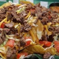 Whole Lotta Steak Nachos · Crispy tortilla chips smothered with queso and topped with cheddar jack cheese, lettuce, tom...