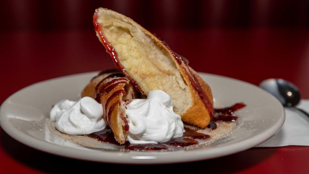 Deep-Fried Cheesecake · Creamy cheesecake, rolled up in a pastry shell and deep-fried, served with raspberry jam, sugar glaze, cinnamon sugar and whipped cream. Sweet!
