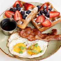 Waffles & Eggs · 2 belgian waffles topped with strawberries and blueberries, two eggs your style, bacon, mapl...