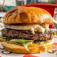 The Wynwood Burger · 8oz Angus Beef on top of arugula with caramelized onions and melted gorgonzola cheese on a b...