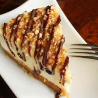 Turtle Cheesecake Slice · Large slice of our NY-style cheesecake topped with our homemade salted caramel and chocolate...
