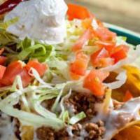 Grande Nachos · A bed of tortilla chips, topped with beans, seasoned shredded chicken or ground beef, lettuc...