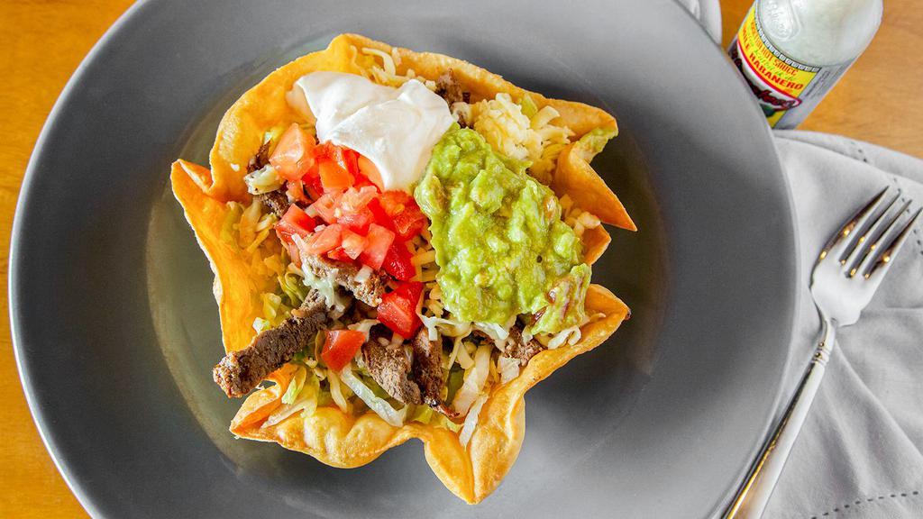 Taco Salad Cazuela · A bowl shaped flour tortilla deep fried and filled with your choice of meat, lettuce, cheese, tomato, sour cream and guacamole.