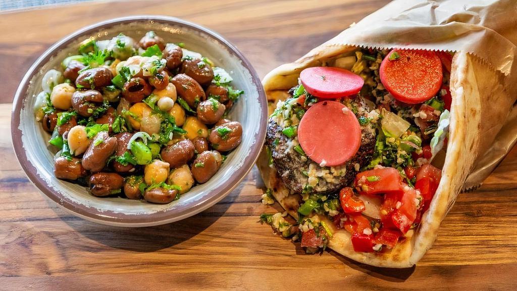 Falafel Wrap · fried patties of ground chickpeas, herbs & spices, pickled radish, tabbouleh, lettuce, tomato, onion, tahini sauce (V+)