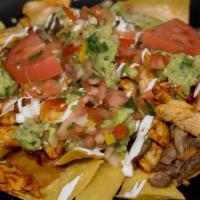 Nachos Monarca · Our signature nachos with grilled chicken and steak over cheese and bean nachos, topped with...