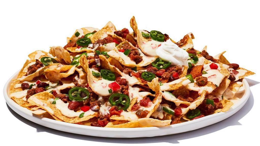 Tex-Mex Nachos Chili · Fresh-made corn chips loaded with cheese and chili, piled high with diced tomatoes, jalapenos and sour cream.
