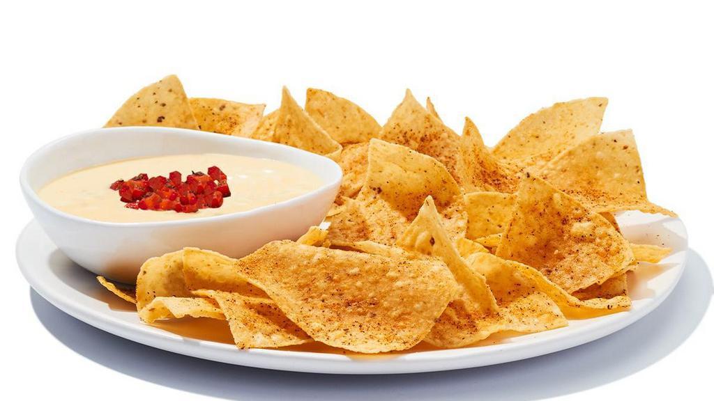 Chips & Queso · A creamy blend of melted cheeses mixed with roasted red and green peppers, topped with diced tomatoes.  Scoop it up with fresh-made corn chips.