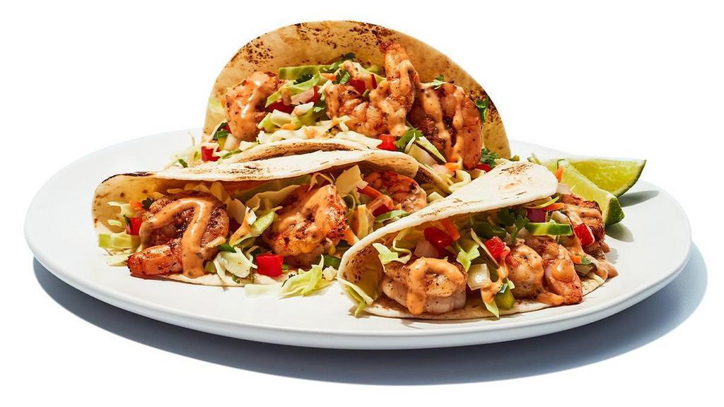 Baja Shrimp Tacos · Baja Shrimp Tacos - We grill seasoned shrimp, then wrap them in flour tortillas with an un-shrimp amount of cabbage, diced tomatoes and special sauce.  Welcome to flavor beach.